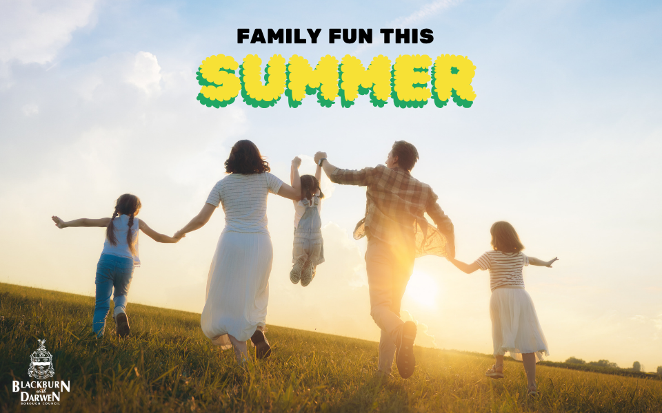 A family of five runs hand in hand across a grassy hill at sunset, with one child being lifted into the air between two adults. The words "Family Fun This Summer" appear at the top of the image in bold black and yellow lettering, and the Blackburn with Darwen Borough Council logo is displayed in the bottom left corner. The bright, open landscape and warm sunlight create a joyful, family-friendly atmosphere.