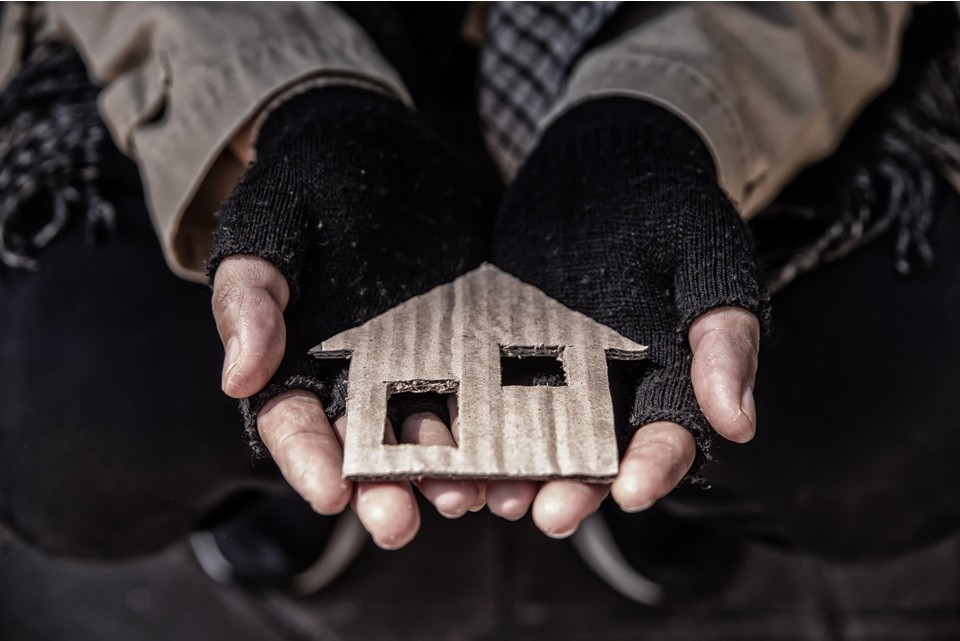 Small cardboard house being held in two hands