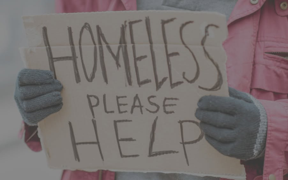 Person holding sign saying 'homeless please help'