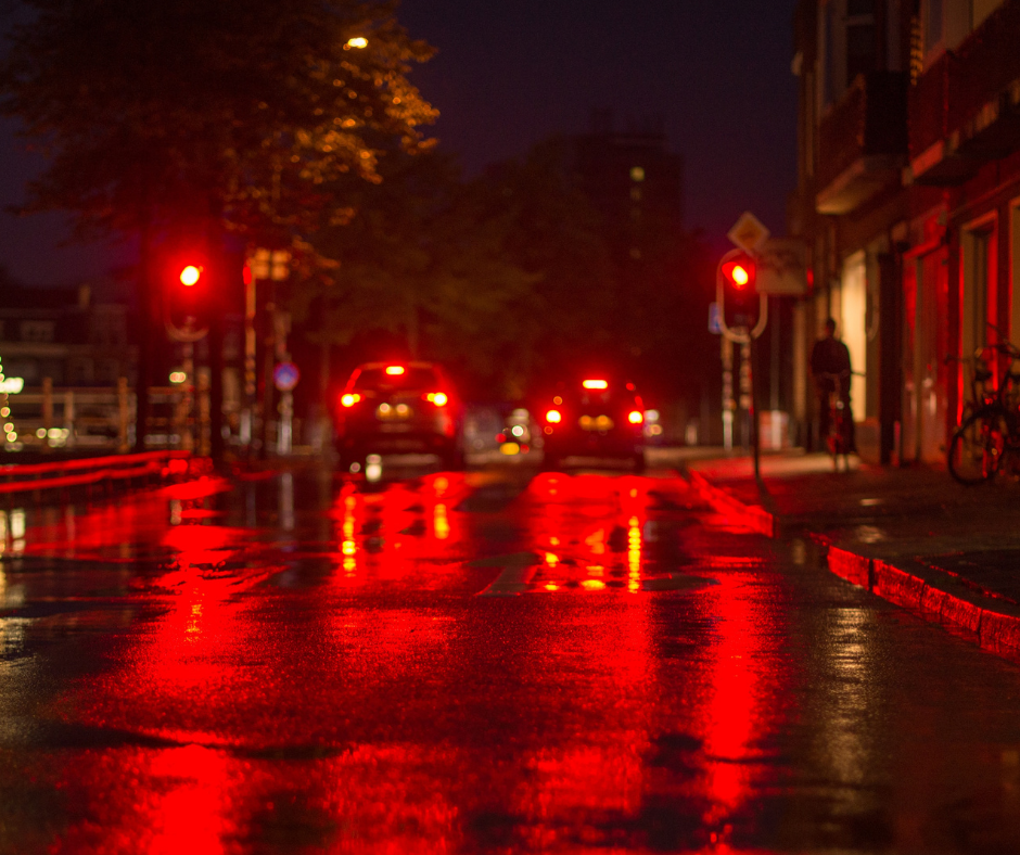 two cars at red traffic light night time