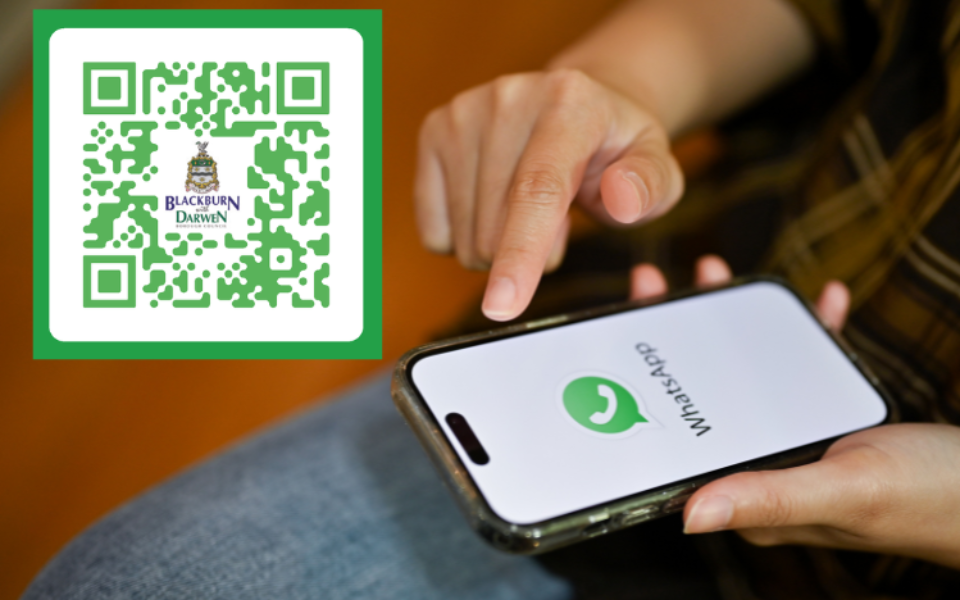 An image of a QR code and a phone with WhatsApp